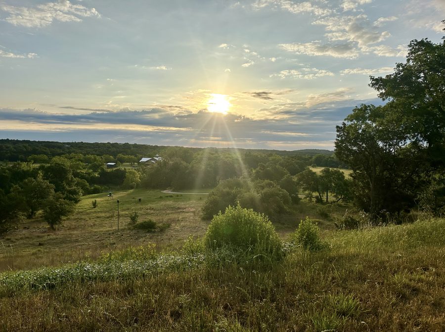 The sun setting over open rolling hills